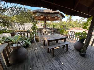 une terrasse avec une table en bois, des bancs et des plantes dans l'établissement Mount Pinatubo Base Camp at CASA HERMOGINA, à Santa Juliana