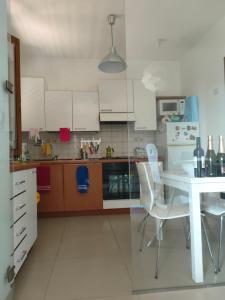 eine Küche mit weißen Schränken sowie einem Tisch und Stühlen in der Unterkunft Decameron in Borgo a Buggiano