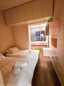 2 camas en una habitación pequeña con ventana en Golden key en Jerusalem