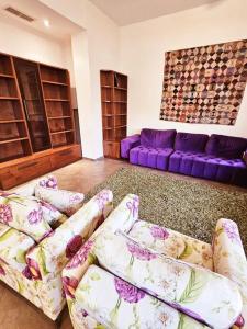 uma sala de estar com sofás e um sofá roxo em Golden key em Jerusalém