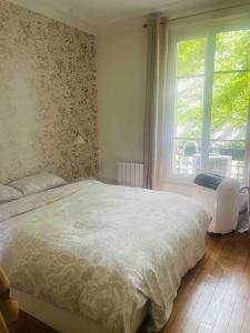 um quarto com uma cama grande e uma janela em JO 2024/ 10min Stade de France em Enghien-les-Bains