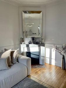 uma sala de estar branca com um sofá e um espelho em JO 2024/ 10min Stade de France em Enghien-les-Bains