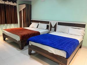 two beds in a hotel room withthritisthritislictslictslicts at C P Hotel in Mahabaleshwar