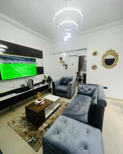 een woonkamer met een bank en een flatscreen-tv bij Owtee’s Apartments in Port Harcourt