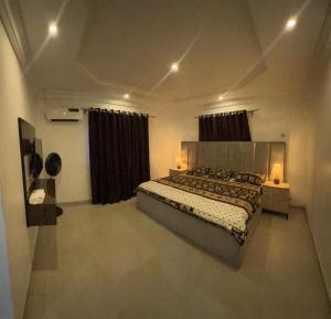 1 dormitorio con 1 cama grande en una habitación en Owtee’s Apartments en Port Harcourt