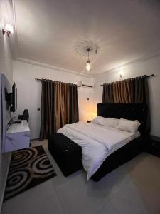 a bedroom with a large bed and a window at Owtee’s Apartments in Port Harcourt