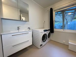a bathroom with a washing machine and a sink at Leirvik i Sogn-Apartment in Leirvik