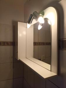 a bathroom with a mirror and a light at LOUNA in Metsovo