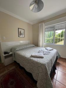 ein Schlafzimmer mit einem Bett mit zwei Handtüchern darauf in der Unterkunft Pousada La Sierra in Campos do Jordão