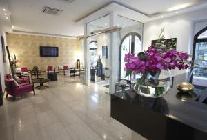 a lobby with a vase of purple flowers on a table at Design Merrion Hotel in Prague