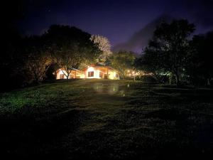 畢哈瓜的住宿－Cabañas Areno Lodge，夜晚在田野里,灯光照亮的房子