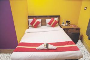 sypialnia z dużym łóżkiem z czerwonymi i żółtymi ścianami w obiekcie Star VIP-Inn Kolkata Airport w mieście Kolkata