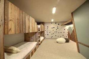 Habitación infantil con literas y pared con pared de escalada. en Chalet Topaz - 18 Couchages Sur les Pistes avec Services, en Plagne Villages