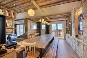 comedor con mesa de madera y sillas en Chalet Topaz - 18 Couchages Sur les Pistes avec Services, en Plagne Villages