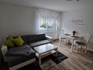 een woonkamer met een bank en een tafel bij Willi´s Ferienwohnung in Heroldsberg