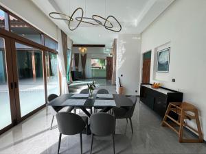 uma sala de jantar com uma mesa preta e cadeiras em Ocean Palms Luxury Villa Bangtao Beach Phuket em Praia de Bang Tao