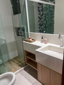 ein Bad mit einem Waschbecken, einer Dusche und einem WC in der Unterkunft Triplex independente in Cabo Frio