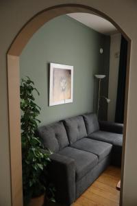 een woonkamer met een grijze bank en een plant bij Hotel Brasserie de Kroon in Gulpen