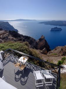 a balcony with chairs and a view of the water at Kamares Apartments in Fira