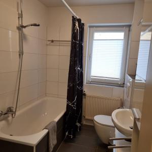 ein Badezimmer mit einer Badewanne, einem WC und einem Waschbecken in der Unterkunft Emma in Oldenburg