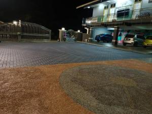 pusty parking w nocy z budynkiem w obiekcie Airport Kelantan HOMESTAY & TRANSIT ROOM w mieście Kota Bharu