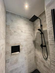a shower in a bathroom with a stone wall at Ferienwohnung Seegras in Emden