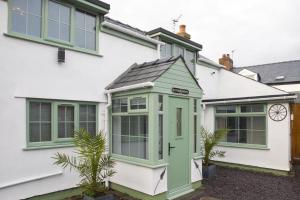 a house with a green door and windows at Botanic Mews in Southport
