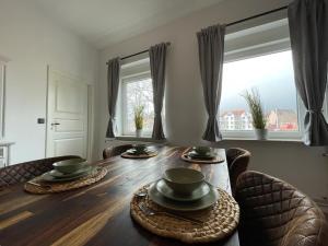 a dining room table with two chairs and two windows at Ferienwohnung Seegras in Emden