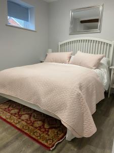 1 dormitorio con cama con edredón blanco y alfombra en The Old Barn one bedroom apartment in Overton, en Overton