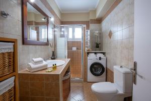 a bathroom with a sink and a washing machine at Lia's Cozy House in Lefkada +35 photos