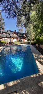una piscina frente a una casa en Aldeas de Vacaciones - Feriendorf en Villa General Belgrano