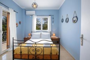 a bedroom with a bed with blue walls and a window at Lia's Cozy House in Lefkada