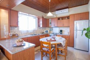 a kitchen with a table and a white refrigerator at Lia's Cozy House in Lefkada