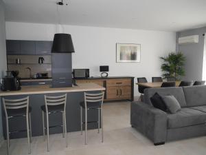 eine Küche und ein Wohnzimmer mit einem Sofa und einem Tisch in der Unterkunft Gîte le Carioca in Chevannes