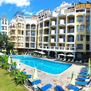 a hotel with a swimming pool and chairs and a building at Diamond Palace in Sunny Beach