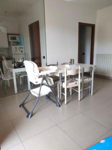 een eetkamer met witte stoelen en een tafel bij Decameron in Borgo a Buggiano