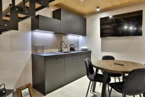 a kitchen with a table and chairs and a sink at Bocianie Gniazdo w Rabce in Rabka-Zdroj