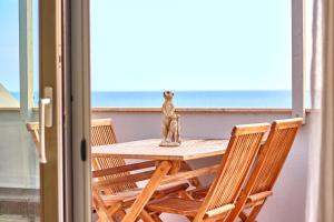 a table with a statue of a dog on a balcony at Corallo Beachfront Penthouse by Bobbywashere in Santa Maria