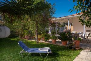 a blue chair sitting on the grass in a yard at Lia's Cozy House in Lefkada