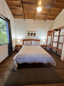 a bedroom with a large bed in a room at Cabañas Areno Lodge. in Bijagua