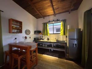 Il comprend une cuisine équipée d'une table et d'un réfrigérateur. dans l'établissement Cabañas Areno Lodge., à Bijagua