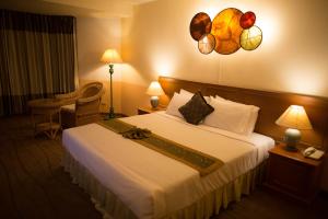Postel nebo postele na pokoji v ubytování Phayao Gateway Hotel