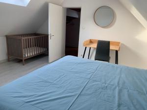 a bedroom with a blue bed and a desk and a mirror at Loft au calme, idéal pour famille, proche de Reims in Saint-Brice-et-Courcelles