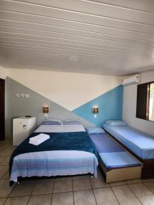 sypialnia z 2 łóżkami i niebieskimi ścianami w obiekcie Flow House w mieście Salinópolis