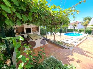 un patio trasero con piscina, mesa y sillas en Villa More Mio, en Poreč