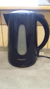 un bollitore per tè blu con un mouse al computer di Appartement cosy de 50m2, 2 chambres avec terrasse, plein centre d'Ax-les-Thermes ad Ax-les-Thermes