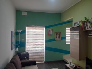uma sala de estar com paredes verdes e azuis em Cosy Home by the Sea em Birzebbuga