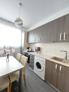 a kitchen with a washing machine and a table at Sweet Residence Apartment in Arad