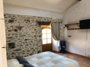 ChamborigaudにあるMas la Tabatièreの石壁のベッドルーム1室、ベッド1台が備わります。