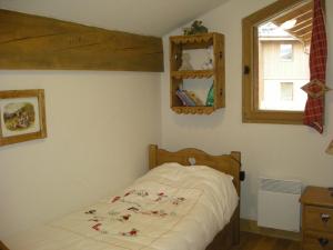 a small bed in a bedroom with a window at les 7 laux immobilier chalet A in Prapoutel